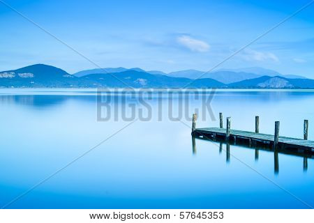 Wooden Pier Or Jetty And On A Blue Lake Sunset And Sky Reflection On Water. Versilia Tuscany, Italy