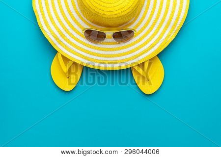 Top View Of Yellow Sunglasses, Striped Summer Retro Hat And Flip-flops. Summer Concept On The Turquo