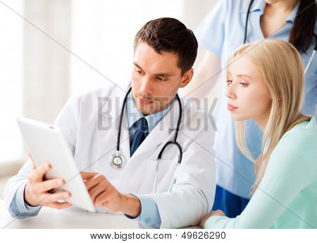 healthcare, medical and technology - doctor showing something patient on tablet pc in hospital