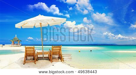 Vista sulla bella spiaggia di sabbia tropicale vuota con ombrellone e spiaggia sedia