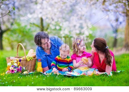 Young Family With Kids Having Picnic Outdoors