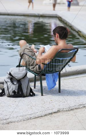 Tourist Reading And Taking Sun