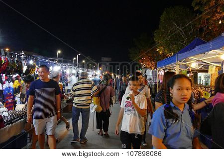 People Walking And Shopping At The Night Market