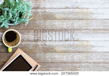 Office desk table- Blank paper notebook with pencil and cup of coffee on wooden table.View from above.Office supplies and gadgets on desk table.Working desk table concept.Writing notes.