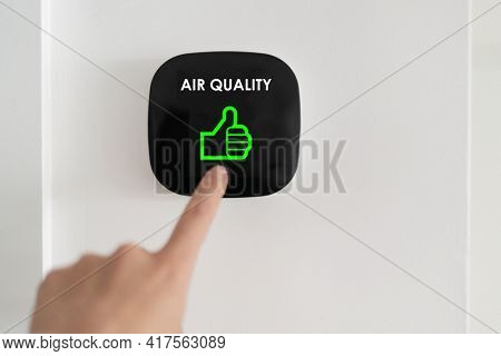 Good air quality indoor smart home domotic touchscreen system. air. Woman touching touchscreen checking air purifier filter at green level with thumbs up graphics.