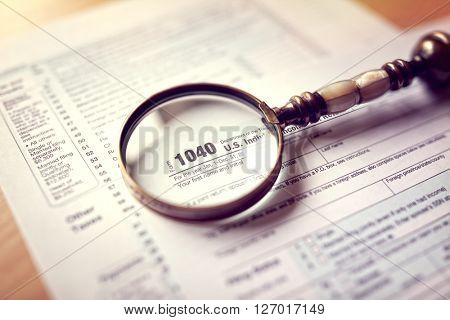 Income tax 1040 us individual tax return form and magnifying glass