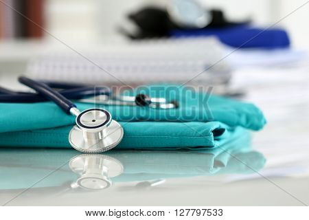 Medical Stethoscope Head Lying On Green Doctor Uniform