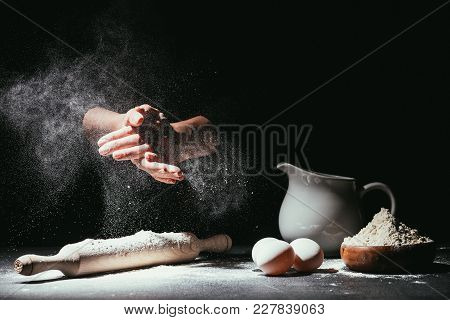 Cropped Shot Of Chef Clapping Ahnds With Flour Before Making Dough On Black