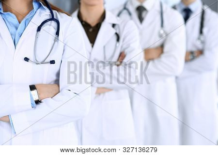 Group Of Modern Doctors Standing As A Team With Arms Crossed In Hospital Office. Physicians Ready To