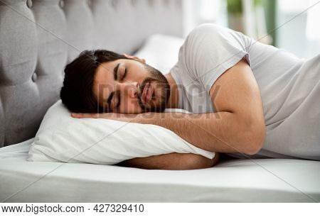 Comfortable Sleep. Millennial Arab Man Sleeping Peacefully And See Sweet Dreams, Lying In Comfy Bed 