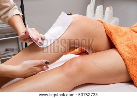 Beautician Waxing A Woman's Leg