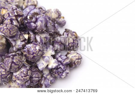 A Pile Of Puprle Candy Coated Popcorn On A White Background