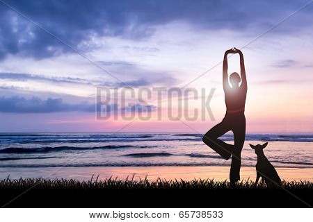 Young woman practicing yoga at sunset