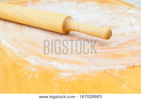 Chopping board with flour and rolling pin on cuisine