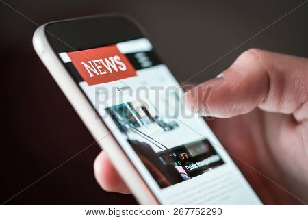 Mobile News Application In Smartphone. Man Reading Online News On Website With Cellphone. Person Bro