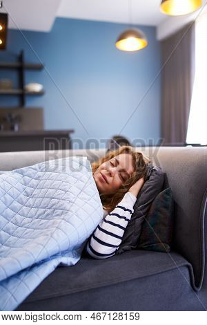 Girl Sleeps On Cozy Sofa In Living Room At Siesta Time Under A Warm Blanket. Sleeping Woman Taking N