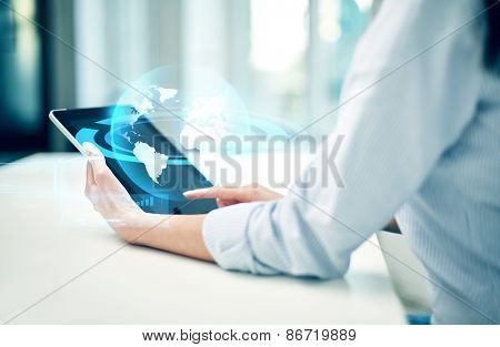 business, technology, communication and people concept - close up of woman with tablet pc computer and globe hologram at office or home