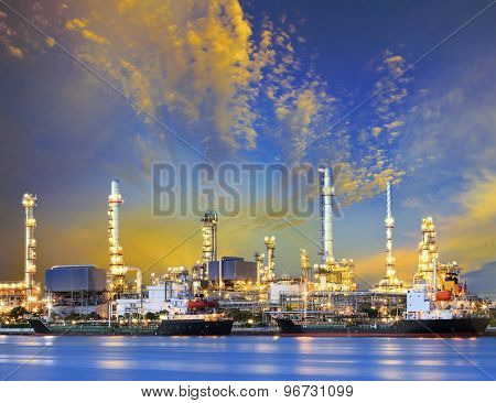 Tanker Ship And Petrochemical Oil Refinery Industry Plant With Beuatiful Lighting Against Dusky Sky