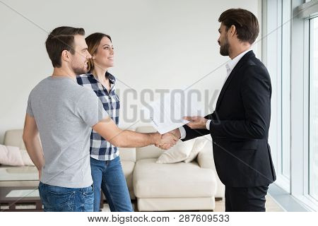 Realtor Or Landlord Handshaking Couple Tenants Make Real Estate Deal