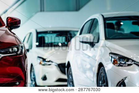 New Luxury Red Shiny Compact Car Parked In Modern Showroom. Car Dealership Office. Car Retail Shop. 