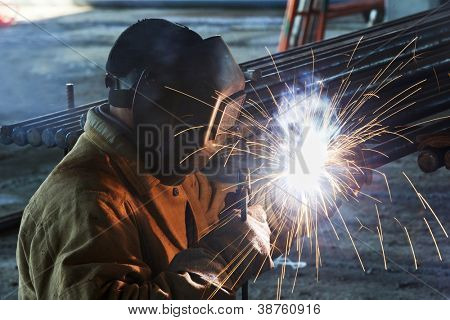 Welder Worker Schweißen Metall mit Elektrode mit hellen Lichtbogen und Funken bei der Herstellung von m