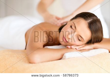 health, beauty, resort and relaxation concept - beautiful woman with closed eyes in spa salon getting massage