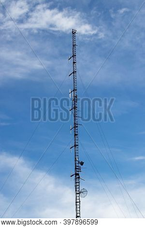 Tall Radio Communication Mast Or Mobile Tower With Antennas And Telecommunication Equipment.