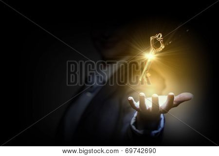 Close up image of business person holding shining key