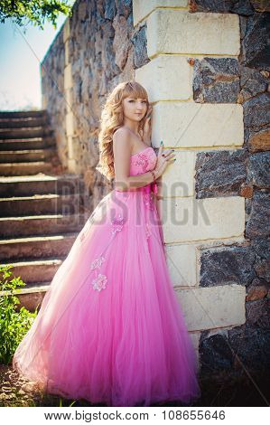 Beautiful young woman in fashionable clothes in the summer garden