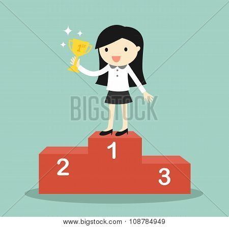 Business concept, business woman standing on the winning podium and holding trophy.