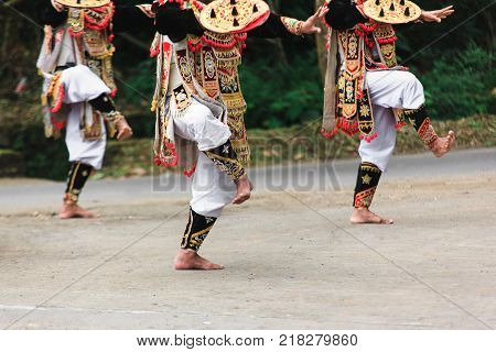 Three Men In Traditional Costumes Perform A Balinese War Dance Called Tari Baris Gede Outdoors. Danc