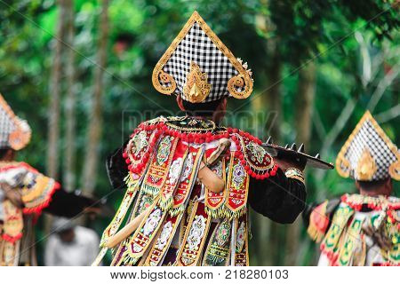 Three Men In Traditional Costumes Perform A Balinese War Dance Called Tari Baris Gede Outdoors. Danc