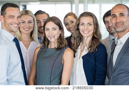 Portrait of successful group of business people at modern office. Happy businessmen and satisfied businesswomen standing as a team in office. Successful group of people smiling and looking at camera.