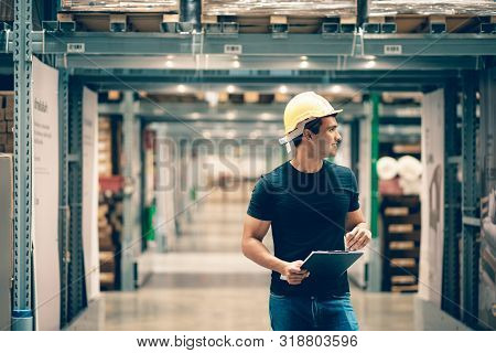 Smart Indian Engineer Man Worker Wearing Safety Helmet Doing Stocktaking Of Product Management In Ca