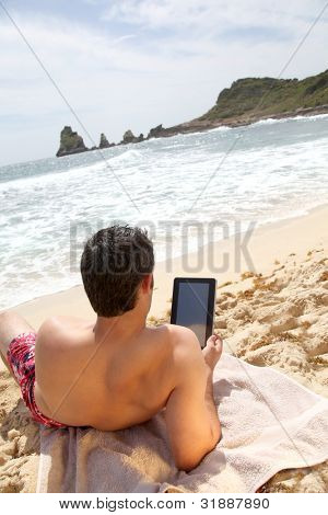 Człowiek za pomocą elektronicznych tabletki na plaży