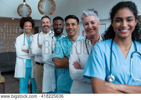 Portrait of group of diverse male and female doctors standing in hospital corridor smiling to camera. medicine, health and healthcare services.