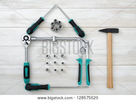 Top view of different type of constructive tools making shape of home, house. Construction instruments and tools. Set of tools. Compact tool box. Mend and repair. Home tool kit.