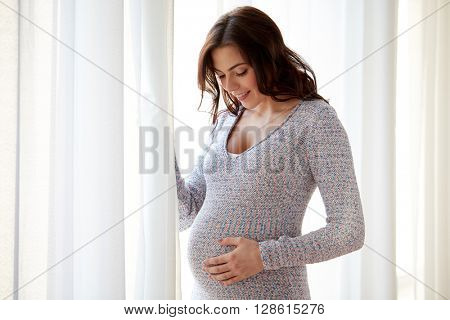 pregnancy, motherhood, people and expectation concept - happy pregnant woman with big tummy at home