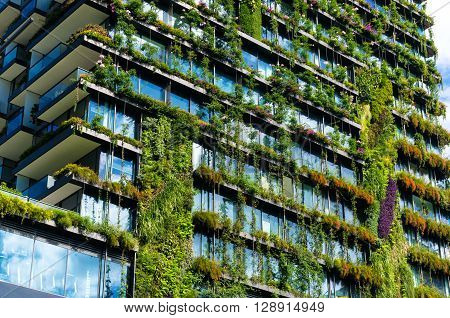 Green skyscraper building with plants growing on the facade. Ecology and green living in city urban environment concept. Park in the sky One central park building Sydney Australia