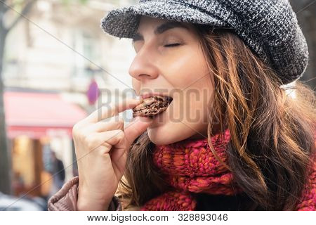 Woman Eating Chocolate Food On Street In Paris In Vacation. Woman Eating Food In Vacation In Paris. 