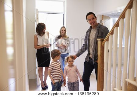 Realtor Showing Young Family Around Property For Sale