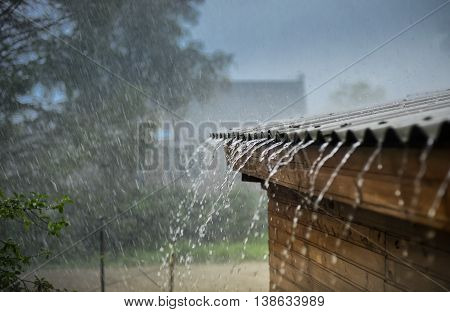 rain flows down from a roof down .