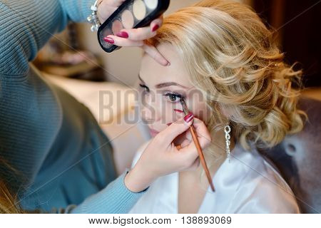 Wedding Makeup Artist Making A Make Up For Bride. Beautiful Sexy Model Girl Indoors. Beauty Woman Wi