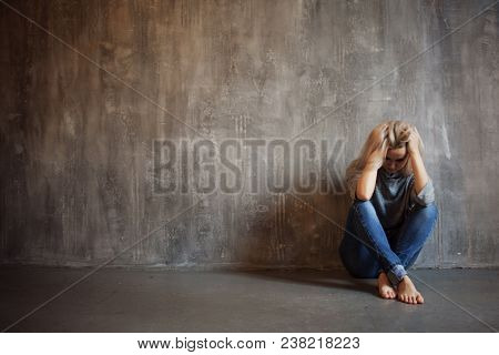 Depressing Girl. Sits On The Floor. Depression And Chronic Fatigue. Young Beautiful Blonde In A Gray