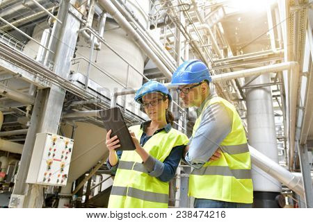 Industrial engineers working in recycling plant with tablet