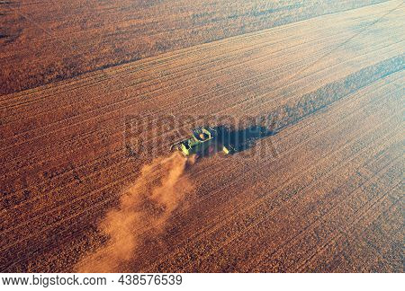 Combine Harvester Working On Harvesting Rapeseed, Aerial View. Farm Harvest Season In Rural. Harvest