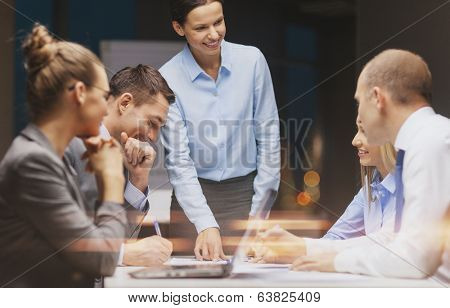 business, technology and office concept - smiling female boss talking to business team