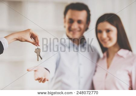 Close Up. Realtor Giving House Keys To Smiling Couple. Real Estate Sales Concept. Getting Access To 