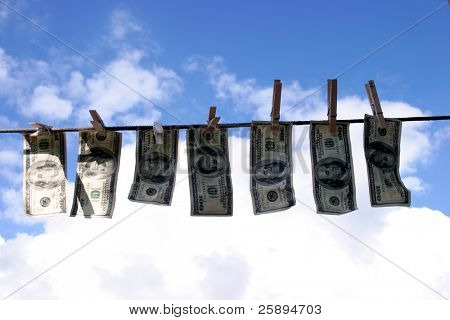 Hundred dollar bills hanging on a rope.
 Money laundering concept 
