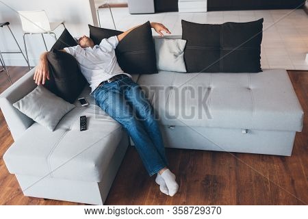 Young Man Watch Tv In His Own Apartment. Picture Of Guy In Deep Sleep Or Daydream. Sitting Or Lying 